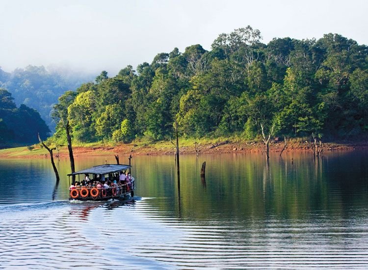 Boat on Periyar Lake beside forested hills