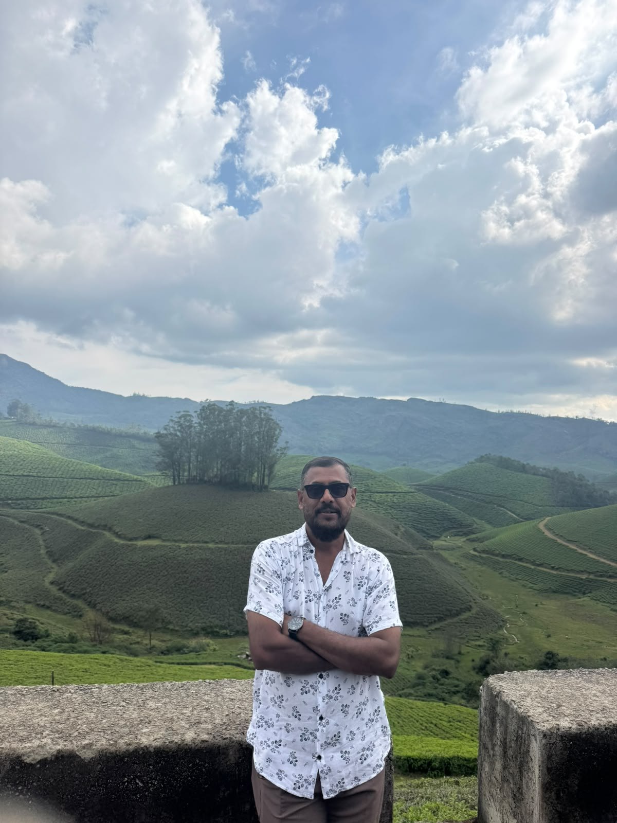 Dennis Anthony with tea-covered hills in the background
