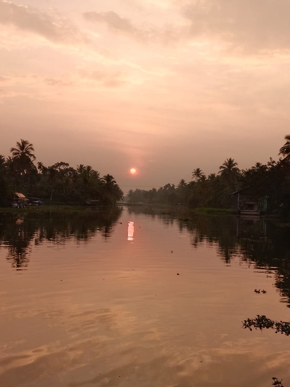 A quiet waterway beneath a warm evening sky