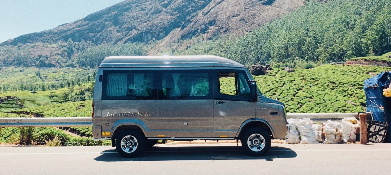 The touring minibus photographed with a hillside backdrop