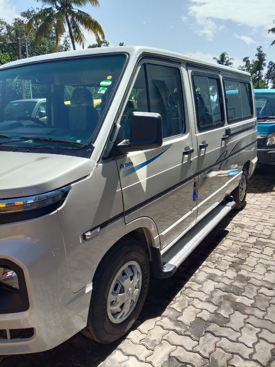 White Tata passenger van viewed from the front and side